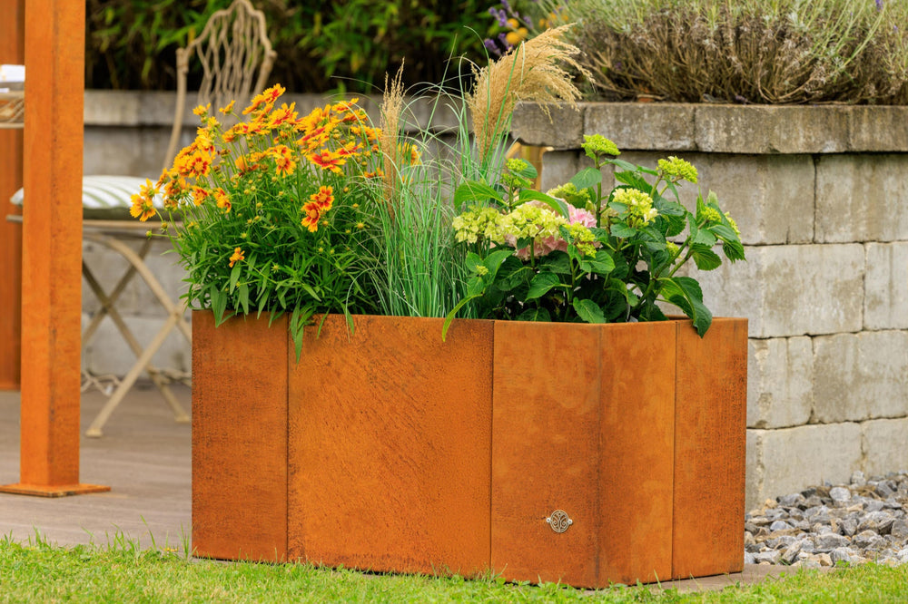 Pflanzkübel Vernazza bepflanzt mit bunten Blumen in einem sommerlichen Garten | Cortenstahl Pflanzkübel Vernazza bepflanzt mit bunten Blumen in einem sommerlichen Garten | Cortenstahl