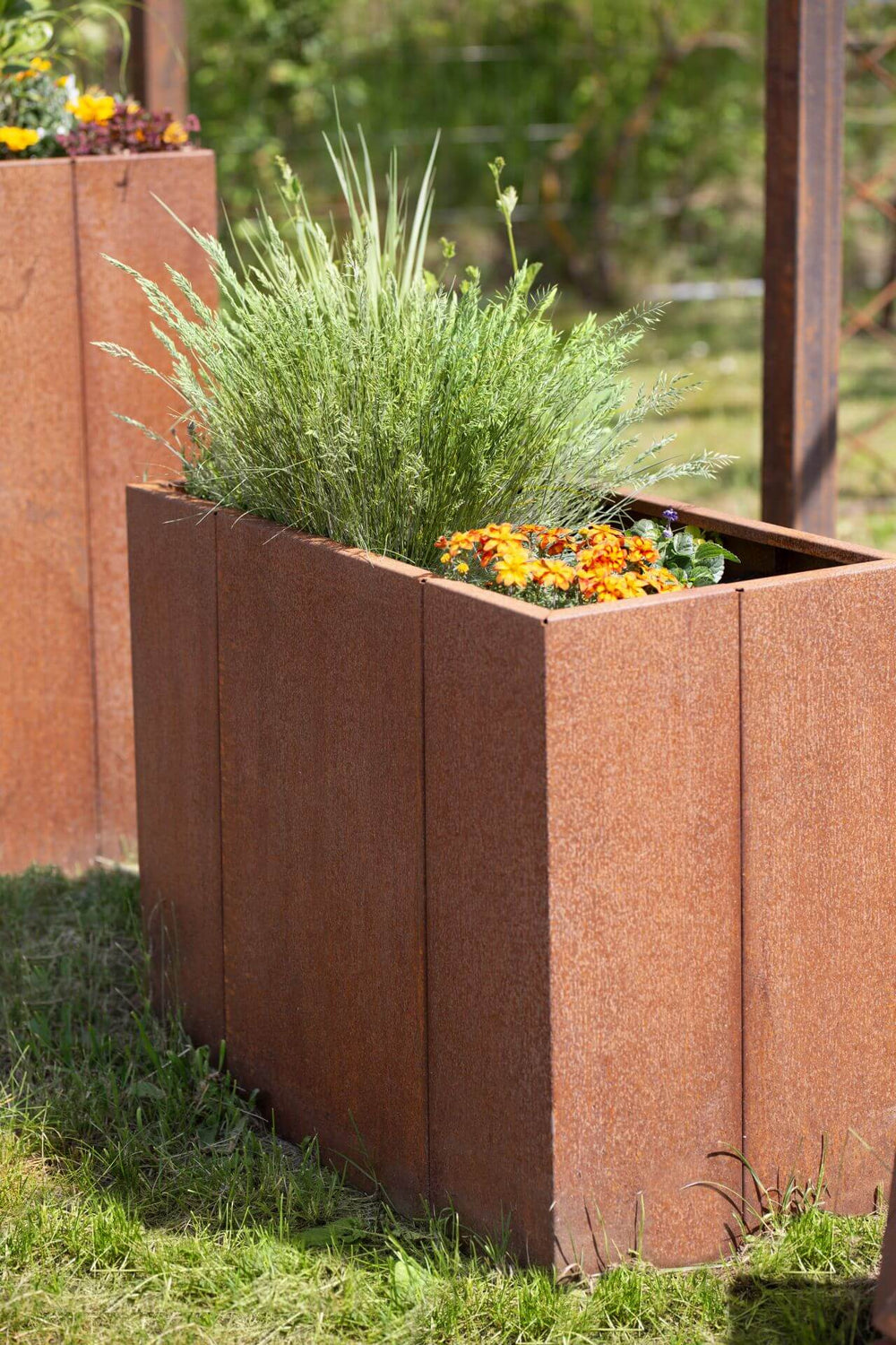 Hochbeet Monterosso bepflanzt in einem Garten bei sommerlichem Wetter | Cortenstahl Hochbeet Monterosso bepflanzt in einem Garten bei sommerlichem Wetter | Cortenstahl
