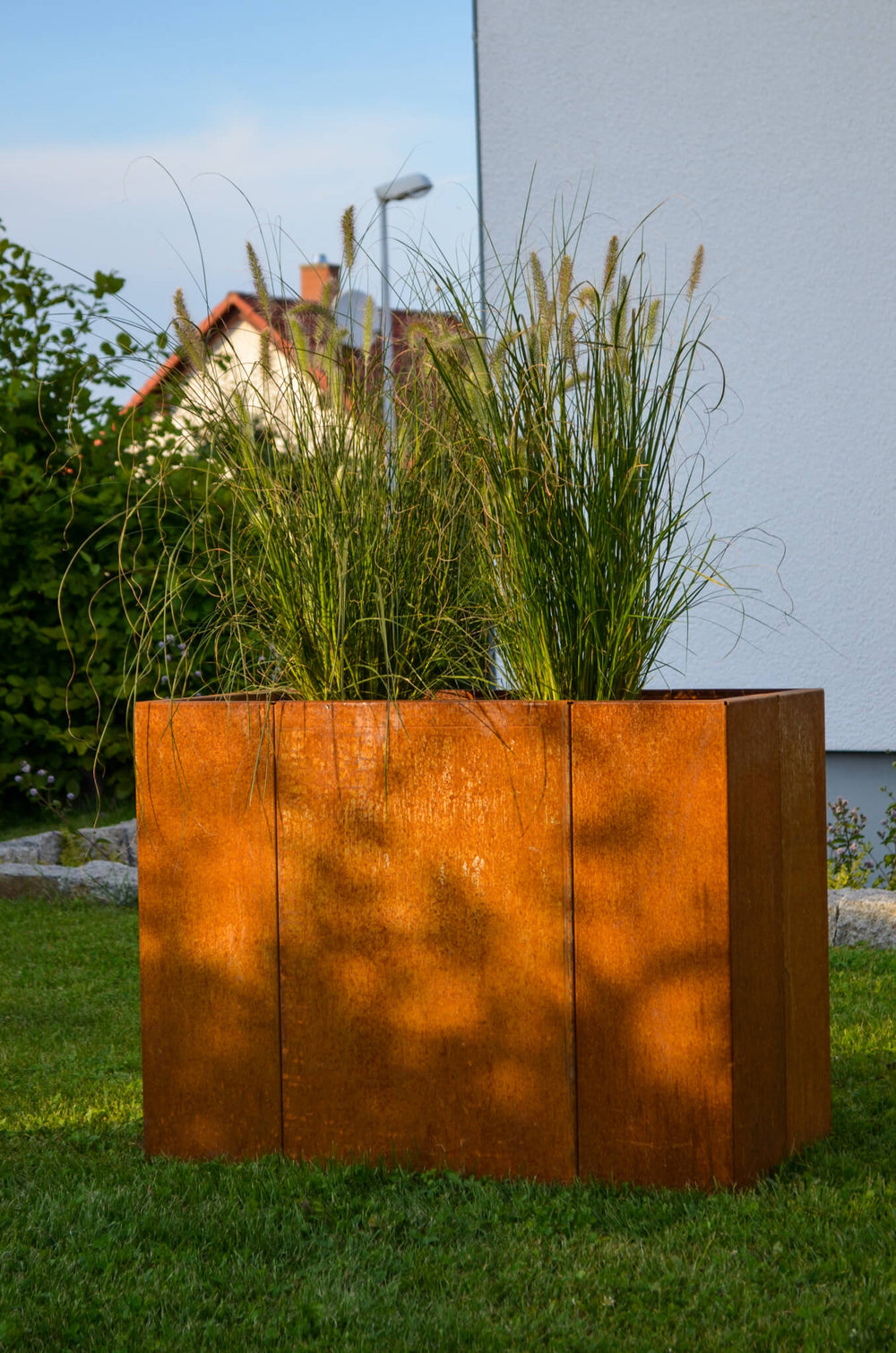 Hochbeet Monterosso bepflanzt in einem Garten | Cortenstahl Hochbeet Monterosso bepflanzt in einem Garten | Cortenstahl