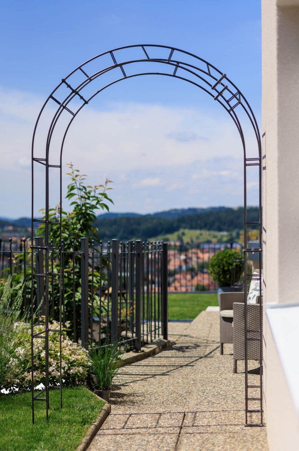 Rosenbogen Cremona als Durchgangsbogen in einem Garten mit schöner Aussicht | Pulverbeschichtet anthrazit Rosenbogen Cremona als Durchgangsbogen in einem Garten mit schöner Aussicht | Pulverbeschichtet anthrazit