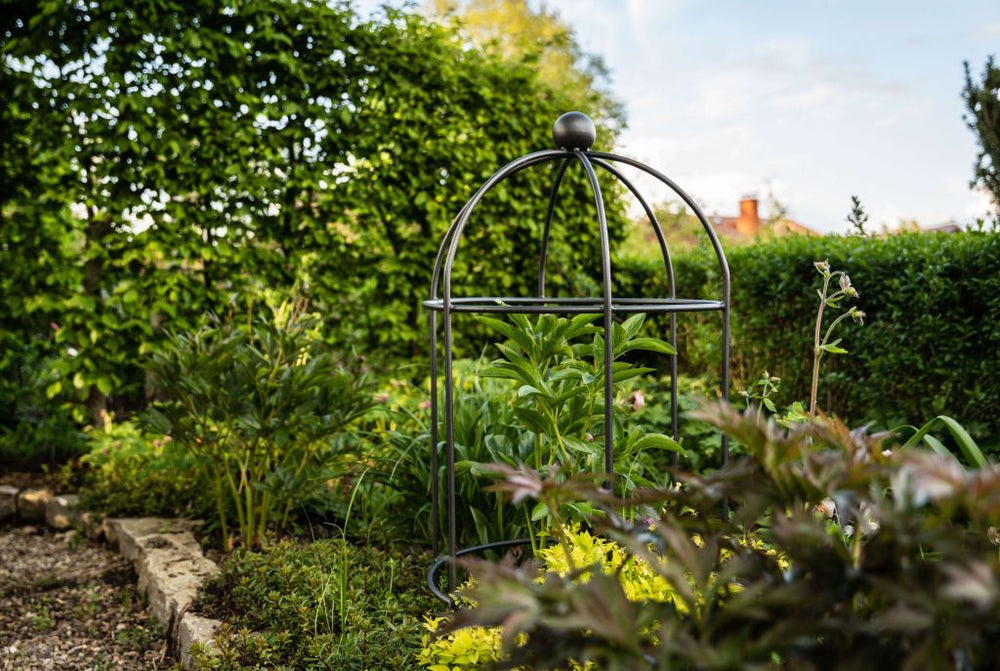 Pflanzstütze Arezzo in pulverbeschichtet Anthrazit in einem bepflanzten Garten Pflanzstütze Arezzo in pulverbeschichtet Anthrazit in einem bepflanzten Garten