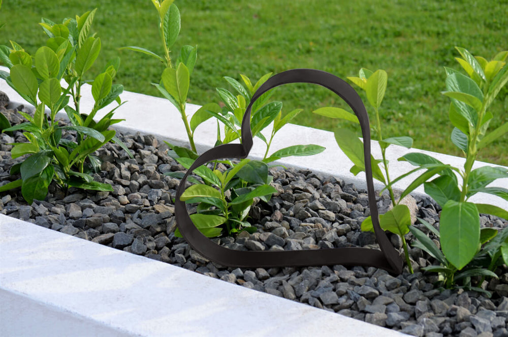 Metallherz Biella in pulverbeschichtet Sonderfarbe RAL 9005 Tiefschwarz auf bepflanzter Beetoberfläche mit Steinen Metallherz Biella in pulverbeschichtet Sonderfarbe RAL 9005 Tiefschwarz auf bepflanzter Beetoberfläche mit Steinen