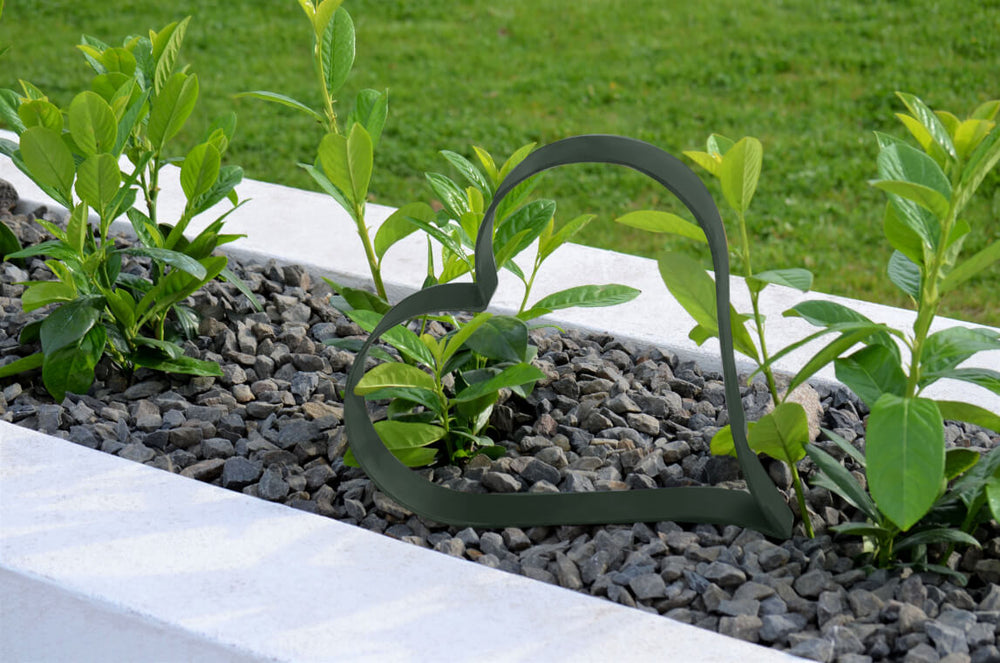 Metallherz Biella in pulverbeschichtet Sonderfarbe RAL 6009 Tannengrün auf bepflanzter Beetoberfläche mit Steinen Metallherz Biella in pulverbeschichtet Sonderfarbe RAL 6009 Tannengrün auf bepflanzter Beetoberfläche mit Steinen