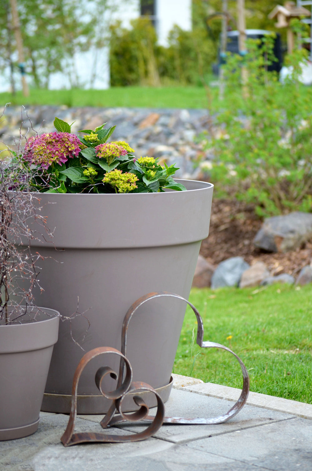 Metallherz Biella und Vercelli vor großem Blumenkübel auf Terrasse, unbeschichtet Metallherz Biella und Vercelli vor großem Blumenkübel auf Terrasse, unbeschichtet