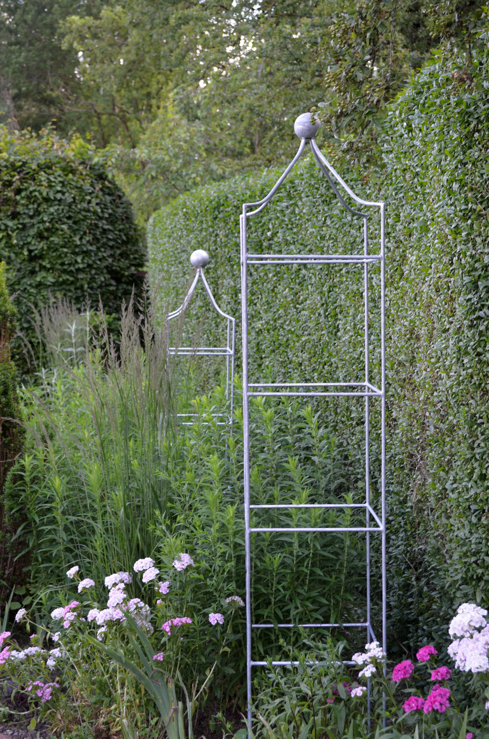 Obeliskenset Catania vor grüner Hecke, feuerverzinkt Obeliskenset Catania vor grüner Hecke, feuerverzinkt