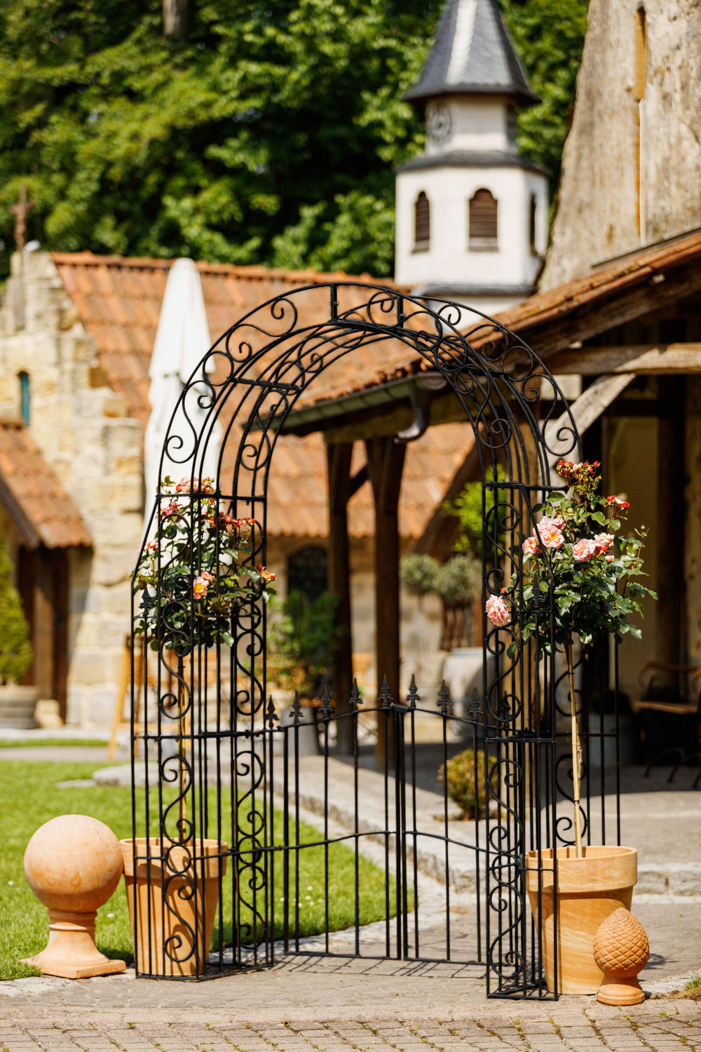 Rosenbogen Calabria mit Tür in pulverbeschichtet Sonderfarbe RAL 9005 Tiefschwarz in einem mediterranen Garten Rosenbogen Calabria mit Tür in pulverbeschichtet Sonderfarbe RAL 9005 Tiefschwarz in einem mediterranen Garten