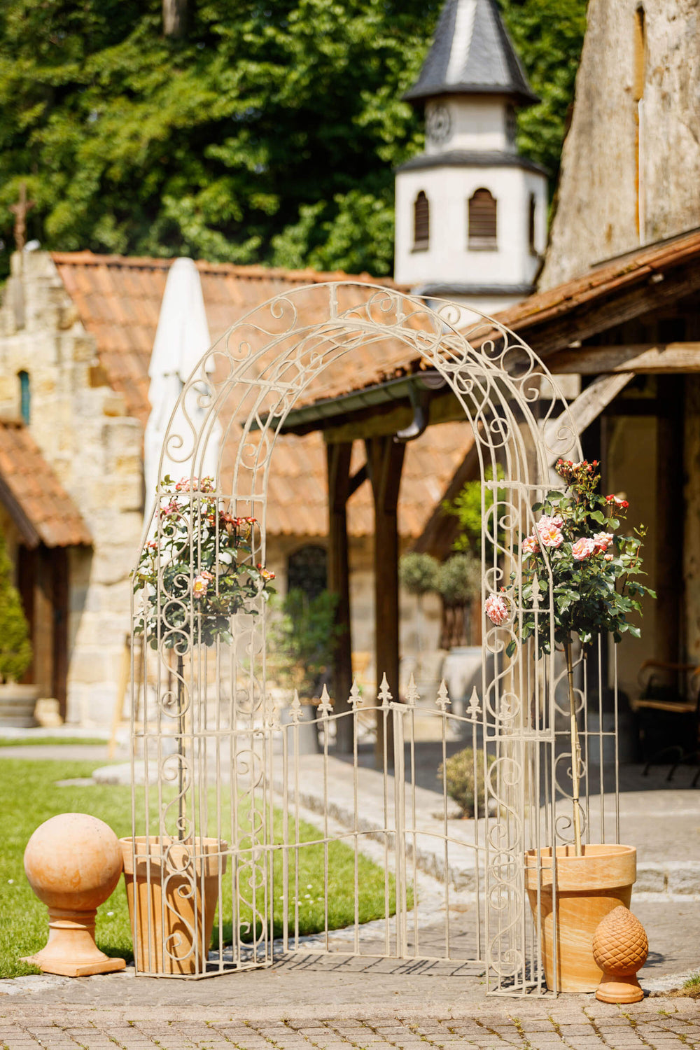 Rosenbogen Calabria mit Tür in pulverbeschichtet Sonderfarbe RAL 9001 Cremeweiß in einem mediterranen Garten Rosenbogen Calabria mit Tür in pulverbeschichtet Sonderfarbe RAL 9001 Cremeweiß in einem mediterranen Garten