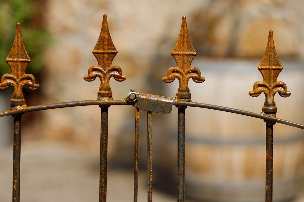 Rosenbogen Calabria mit Gartentor in Rostoptik Detailansicht Schließmechanismus Gartentor und Kreuzlilien-Spitzen Rosenbogen Calabria mit Gartentor in Rostoptik Detailansicht Schließmechanismus Gartentor und Kreuzlilien-Spitzen